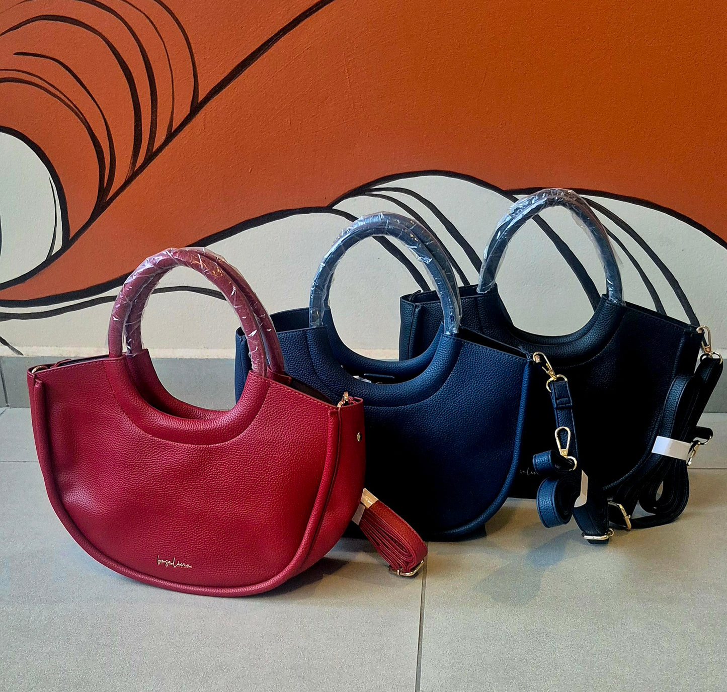 Cartera de mano semicurculo con correa cross